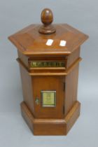 A hexagonal wooden post box. 45 cm high, 27 cm wide.