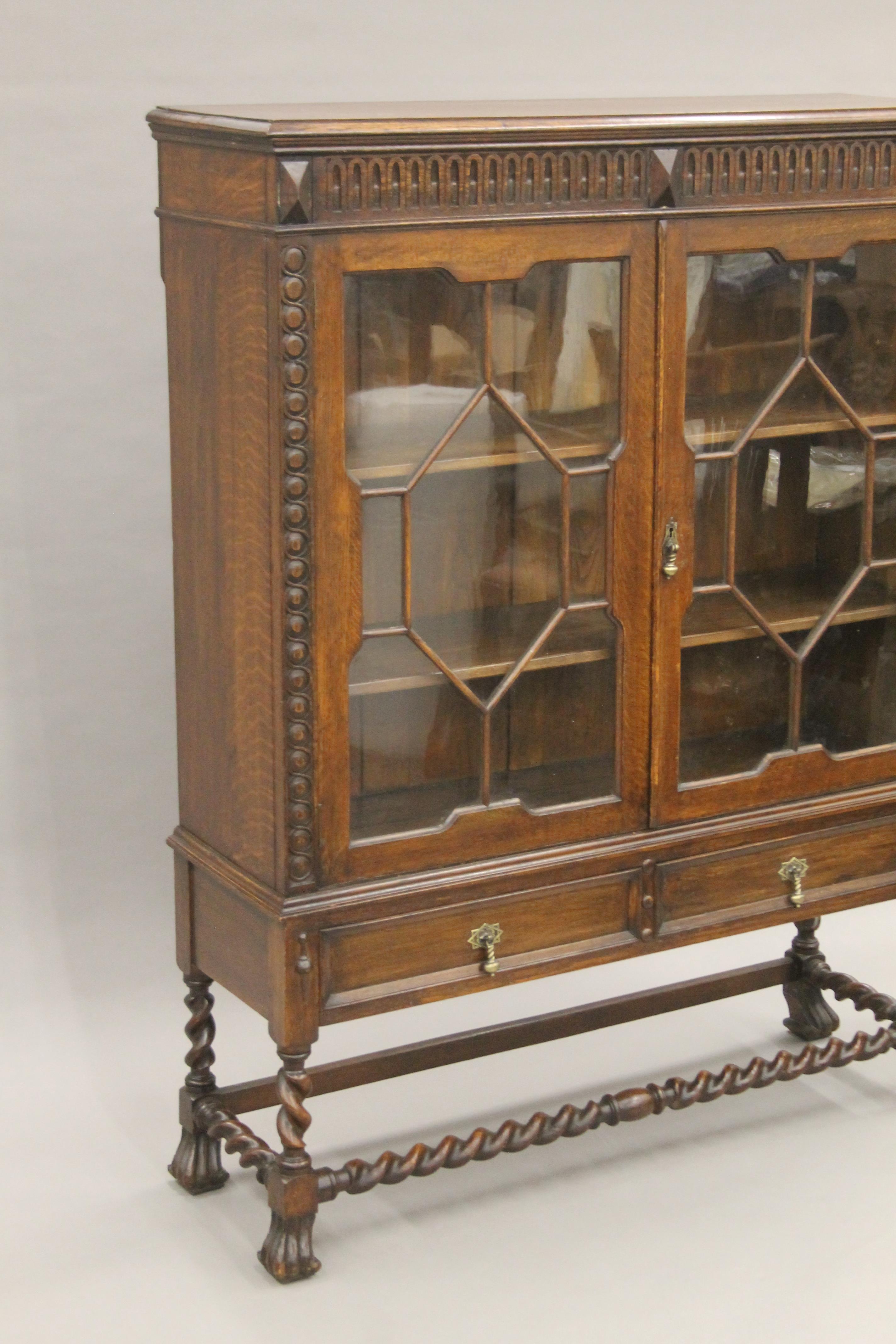 An early 20th century carved oak two door glazed barley twist cabinet. - Image 2 of 5