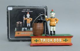 A boxed cast iron Trick Dog money bank. The box 22.5 cm wide.