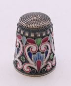 A enamel decorated silver thimble bearing Russian marks. 2 cm high.