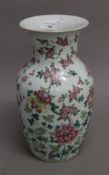 A Chinese white porcelain hand-painted vase with floral designs. Base drilled for lamp.