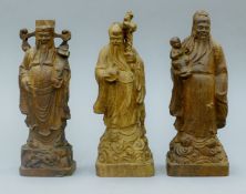 Three hand-carved Chinese figures of dignitaries. The tallest 22 cm high.