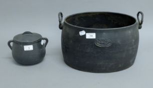 Two cast iron cooking pots. The largest 37 cm wide.