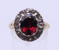 An 18 ct gold garnet and diamond cluster ring. Ring size P/Q.