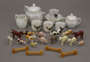 A child's tea set decorated with chickens and a quantity of small wooden animals.