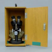 A mid-20th century cased microscope marked Enbecco No. 65120. The case 32.5 cm high.