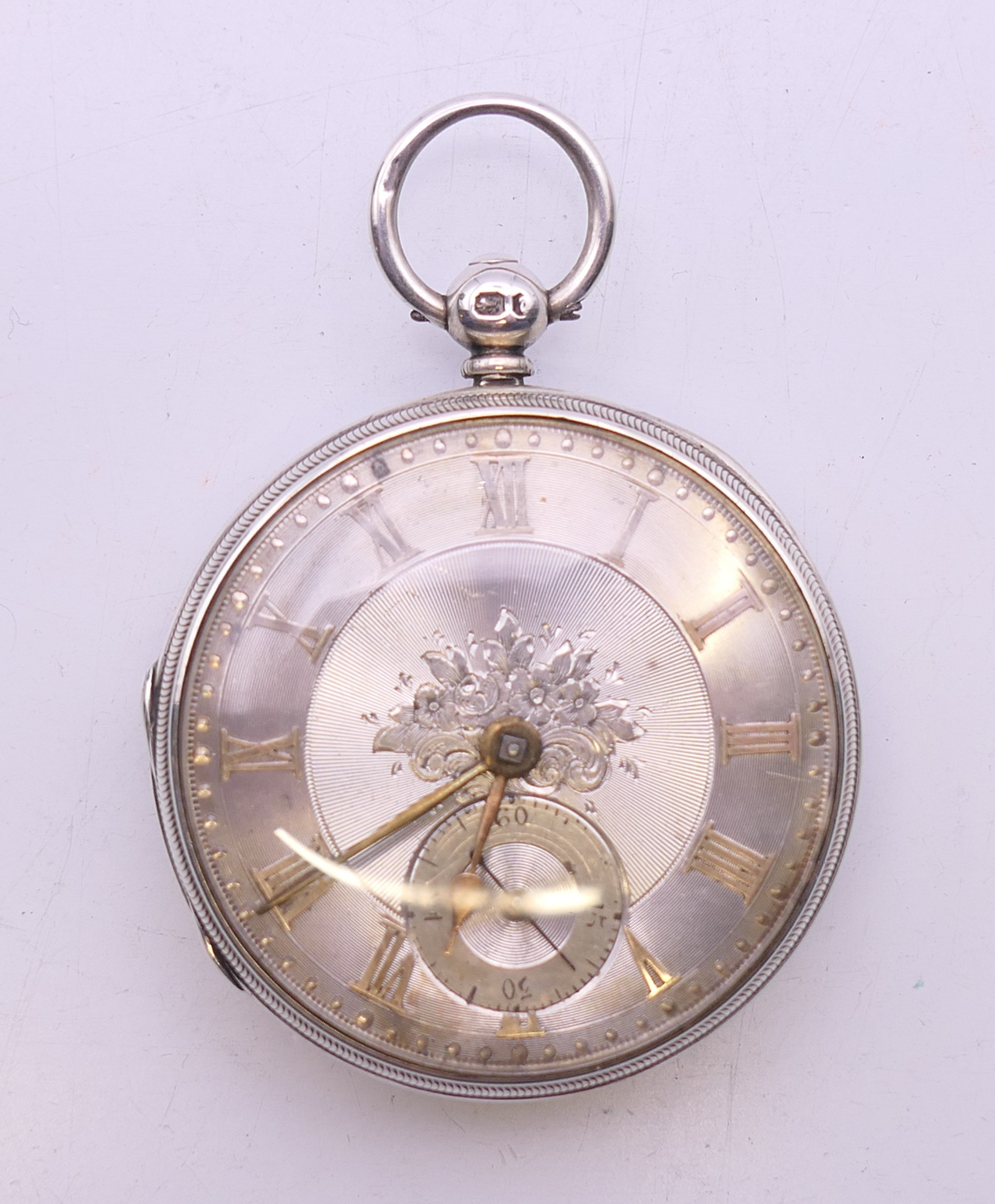 A silver pocket watch with engraved dial, hallmarked for London 1855. 4 cm diameter.