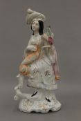A 19th century Staffordshire figure formed as a seated lady falconer wearing a plumed hat,