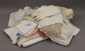 A quantity of vintage clothes, gloves, embroidered table linens etc.