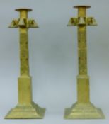 A large pair of Sri Lankan bronze candlesticks, heavily hand-tooled and on square bases. 40 cm high.