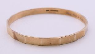 A 9 ct gold bangle with a metal core, inscribed to the interior band 'From Mark to Mollie,