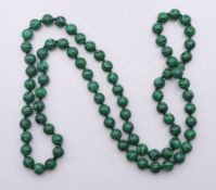 A string of malachite beads. 88 cm long.