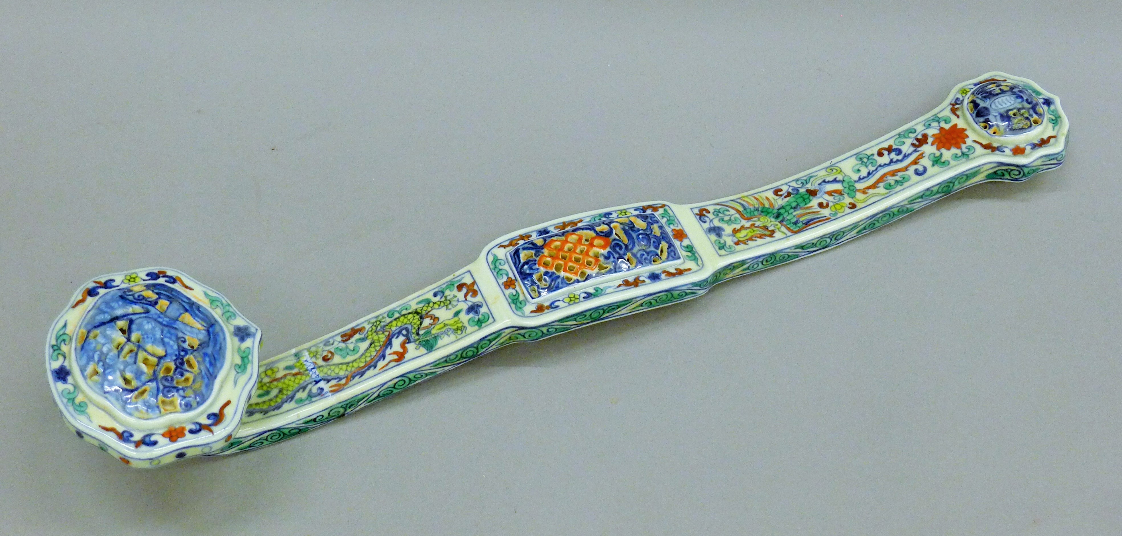 A Chinese porcelain ruyi sceptre with dragon and phoenix decoration. 49 cm long.