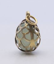 A pierced silver and jade egg pendant. 2.5 cm high overall.
