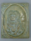 A bronze plaque depicting a puppy. 16.5 cm high.