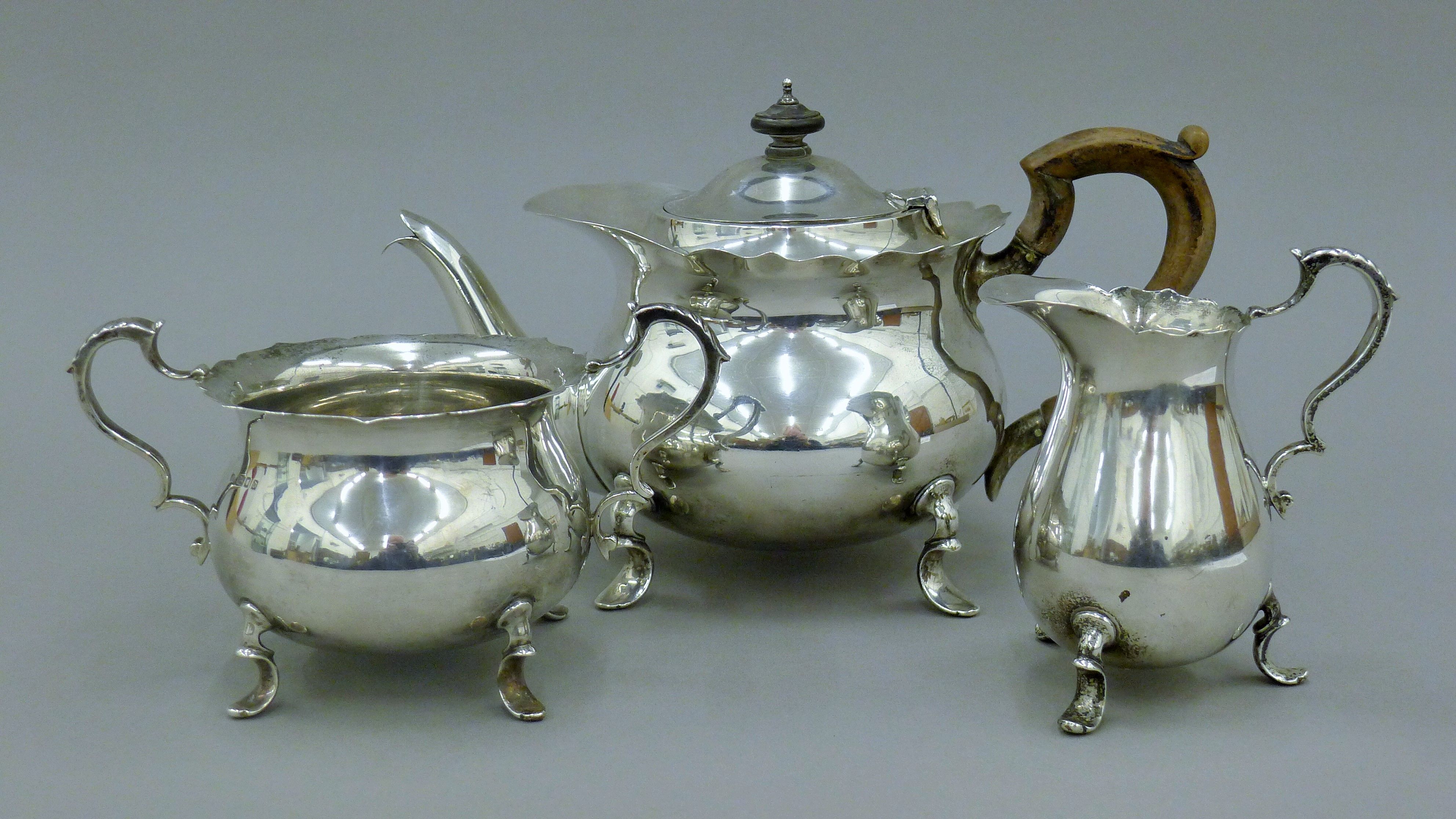 A three-piece silver tea set. The teapot 27 cm long. 34.5 troy ounces total weight.