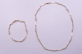A 9 k gold and pearl necklace 45 cm long and matching bracelet 20 cm long. 20 grammes total weight.