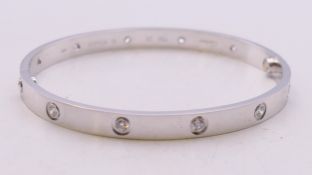 A boxed Cartier 18 ct white gold and diamond love bangle, numbered STA413. 7 cm wide. 37.