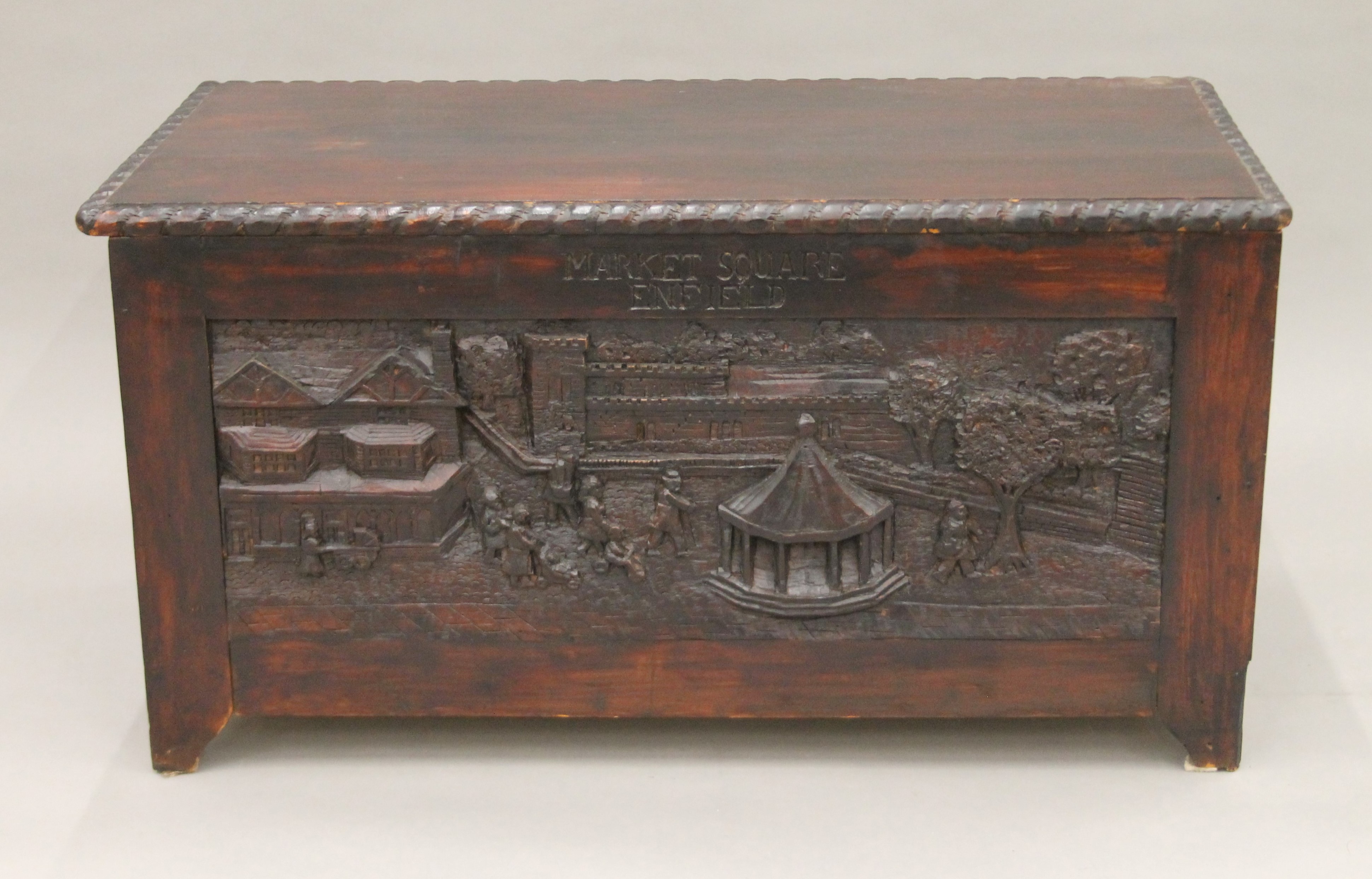 A trunk carved with scenes of Enfield. 88 cm long.