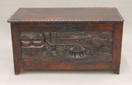 A trunk carved with scenes of Enfield. 88 cm long.