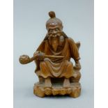 A late 19th century carved figure of an Oriental seated gentleman. 12 cm high.