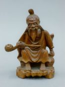 A late 19th century carved figure of an Oriental seated gentleman. 12 cm high.