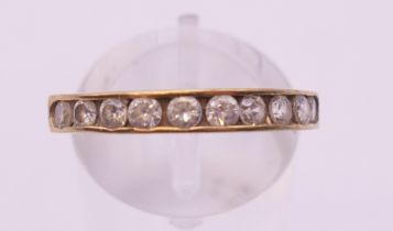 A 9 ct gold cubic zirconia half-hoop eternity ring. Ring size O.