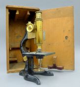An E Leitz, Wetzler brass microscope in a wooden case. The case 34 cm high.