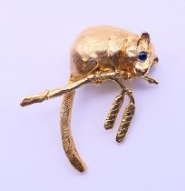 A gold dormouse form brooch with sapphire set eyes. 4 cm high. 13.9 grammes.