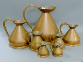 A graduating set of seven copper haystack measures. The largest 42 cm high.