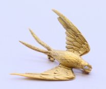 An 18 ct gold swallow form brooch with diamond set eyes. 3.25 cm x 3.5 cm. 6.4 grammes.