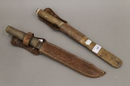 Two Eastern daggers in sheaths. The largest 38 cm long.
