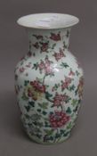 A Chinese white porcelain hand-painted vase with floral designs. Base drilled for lamp.