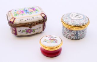 Three small decorative pill boxes, one porcelain, two enamel. The largest 6 cm x 5 cm.