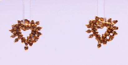 A pair of gold and diamond heart shaped earrings. 1 cm high. 3.1 grammes total weight.