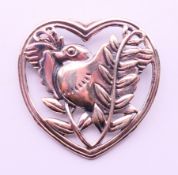 A silver brooch formed as bird within a heart. 4.25 cm high.