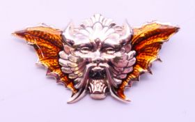 A silver winged devil mask brooch. 5.5 cm x 2.75 cm.