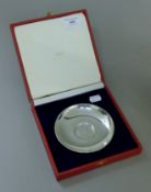 A Cartier pewter plate in presentation box. 12 cm diameter.