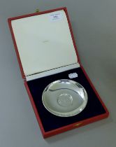 A Cartier pewter plate in presentation box. 12 cm diameter.