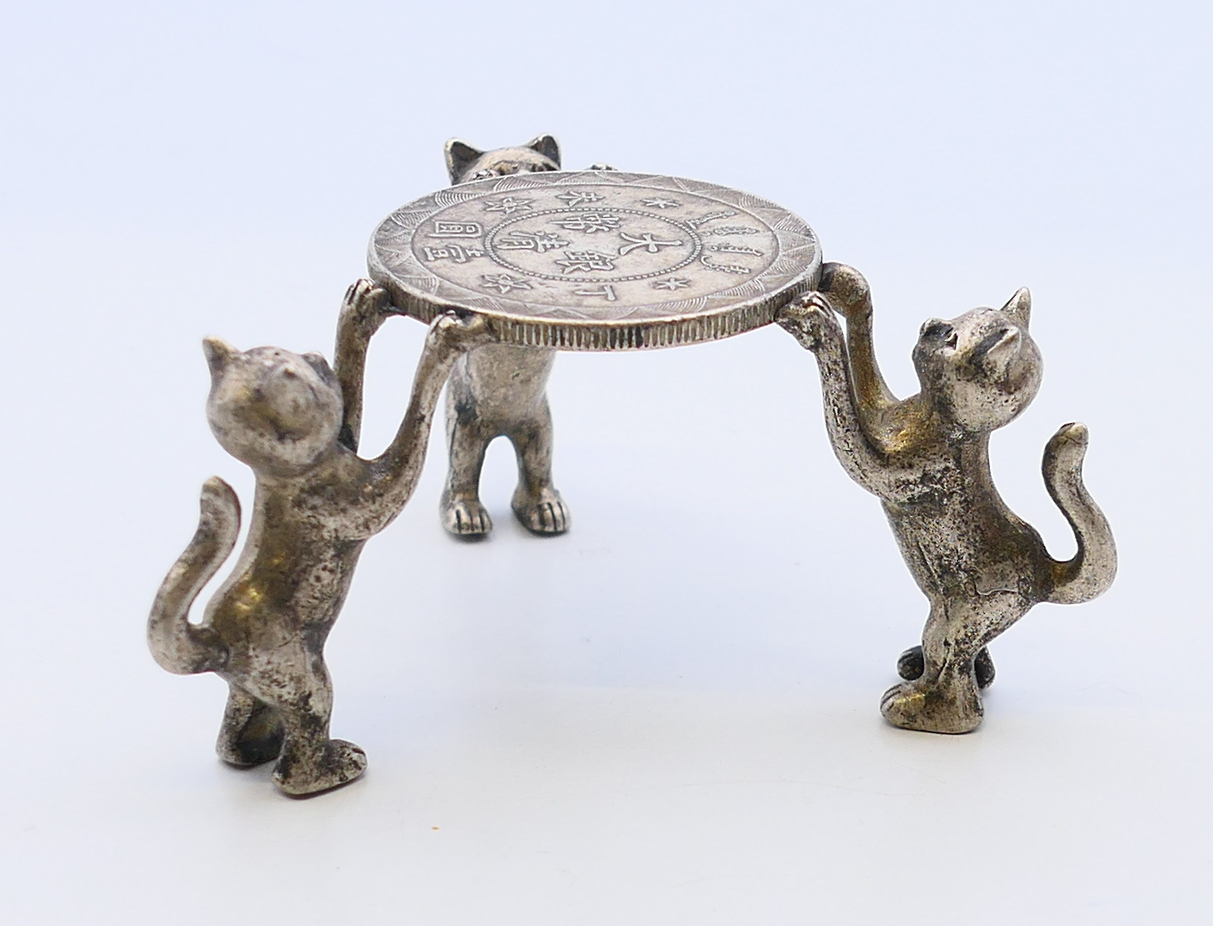 A Chinese small stand, the coin top supported by three cats. 4 cm high.