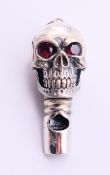 A silver whistle pendant in the form of a skull. 4 cm high.