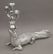 A silver-coloured alligator candelabra. 44 cm high.