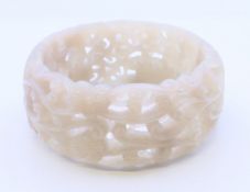 A carved and pierced jade bangle. 6 cm inner diameter.