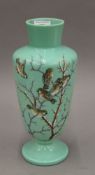 A Victorian painted green glass vase decorated with birds. 31 cm high.