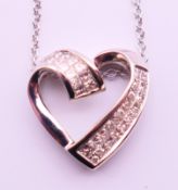 A 14 K white gold and diamond heart shaped pendant on a 14 K white gold chain. Pendant 1.
