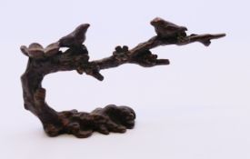 A bronze model of two birds perched on a tree branch. 8.5 cm wide.