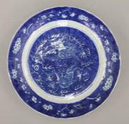 A Chinese blue and white porcelain dish decorated with a dragon. 28 cm diameter.