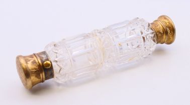 A Victorian cut glass double-ended perfume bottle with brass tops, in a leather case. 13.5 cm long.
