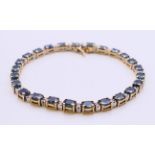 A 14 K gold, diamond and sapphire line bracelet. 18 cm long.