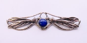 A silver and lapiz dragonfly brooch. 9 cm wide.